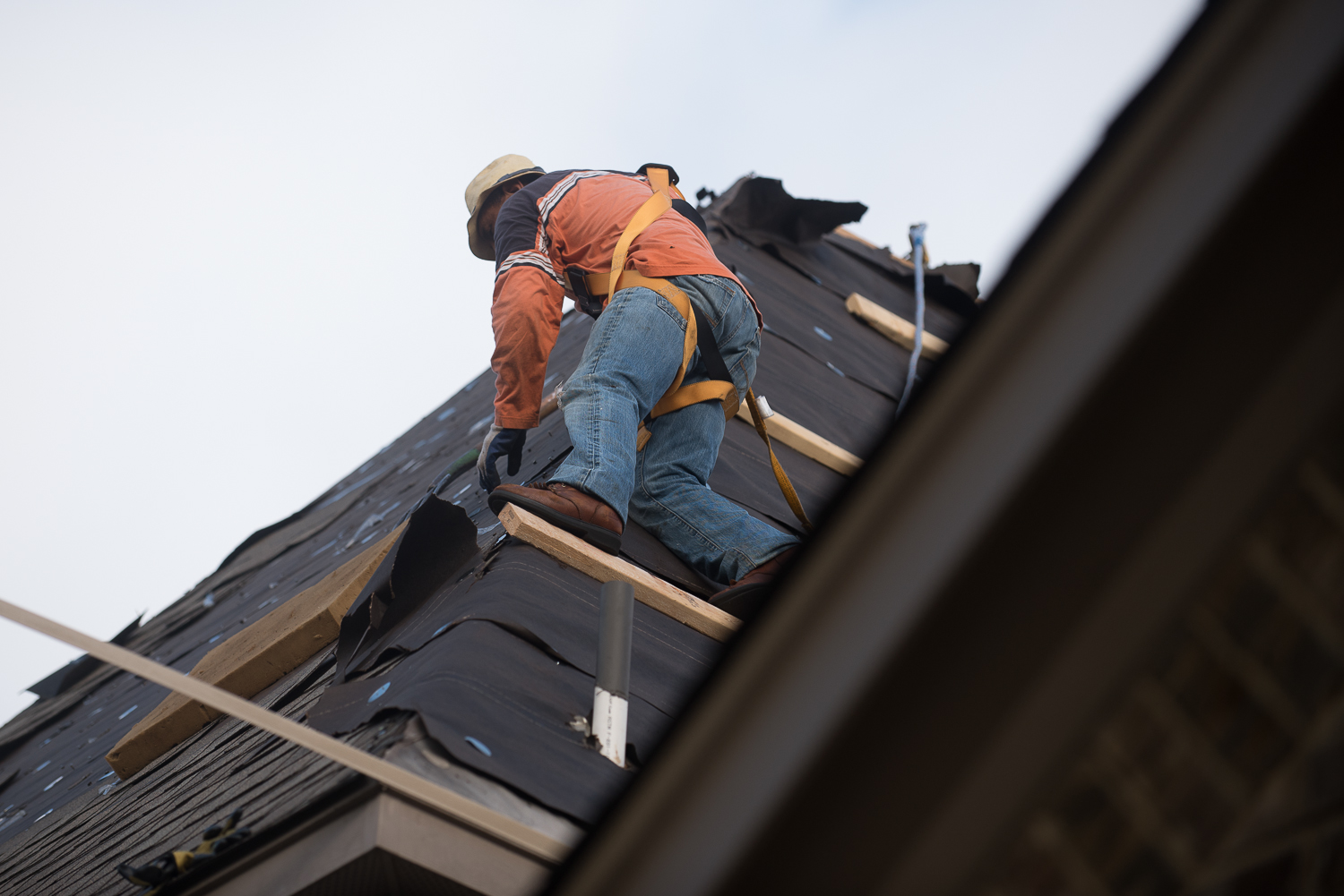 Professional Roofer Working On Steep Roof