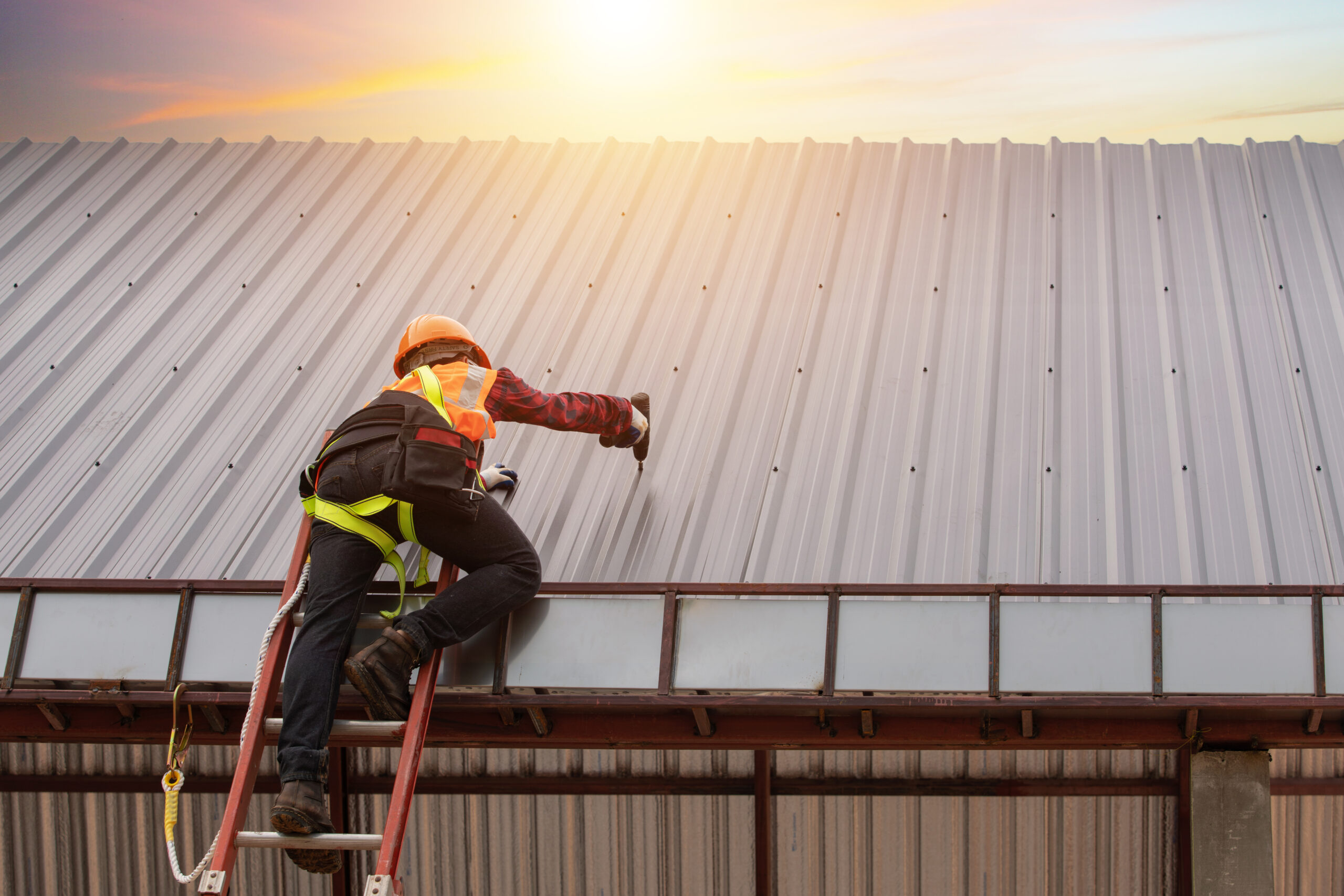 Worker Installing Metal Roofing On Commercial Building