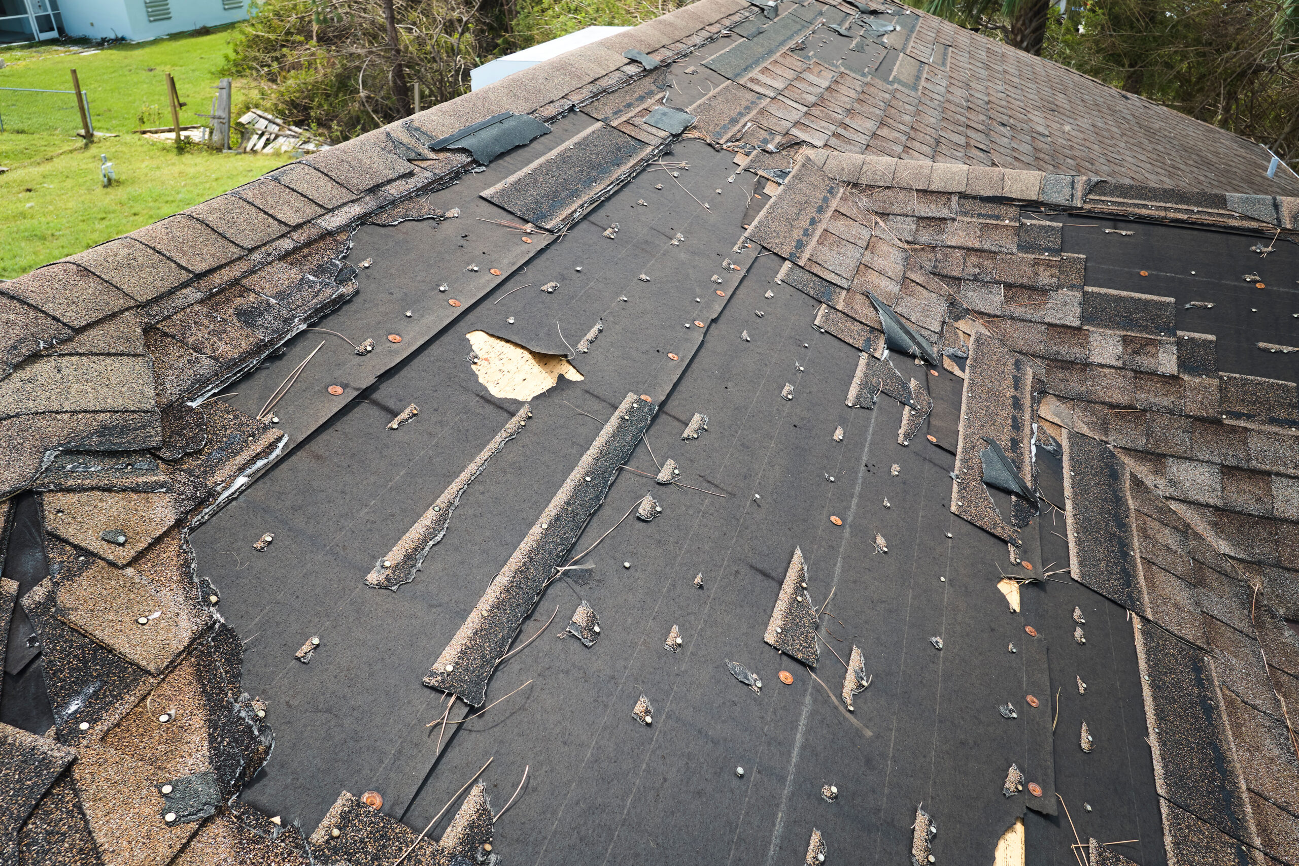 Asphalt Roof With Severe Storm Damage In Need Of Repair